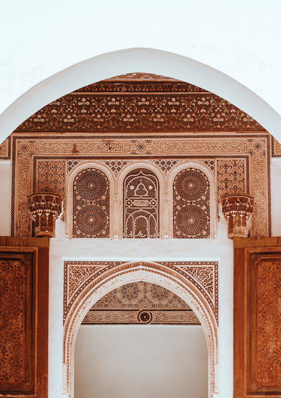 Ornate Moroccan archway with intricate terracotta and cream geometric plasterwork detail
