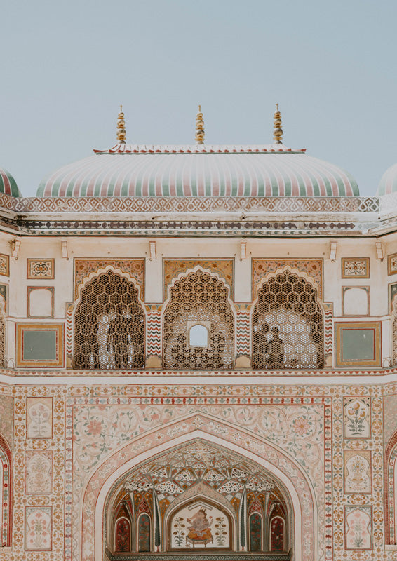 Ornate palace facade with striped dome, gold finials and latticed arched windows in pastel tones.