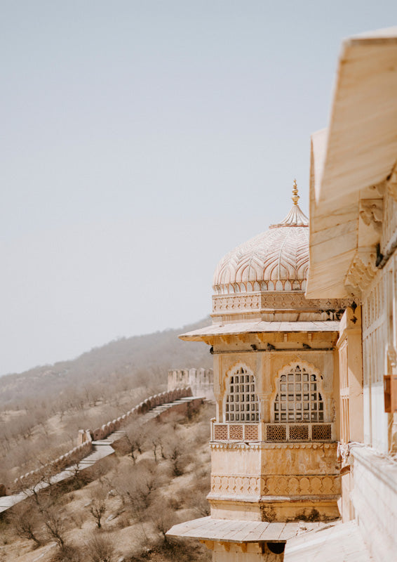 Domed palace balcony overlooking a fortress wall and dry hillside landscape