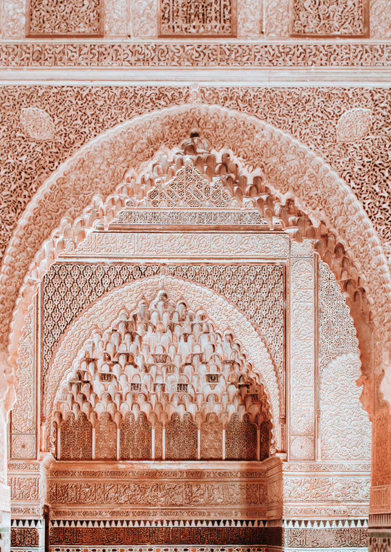 Ornate carved Moroccan archway with muqarnas detail in terracotta and cream tones