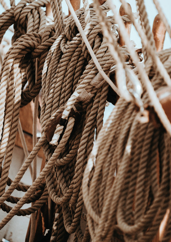 Close-up of coiled rope and rigging hardware on a boat, in brown and cream tones