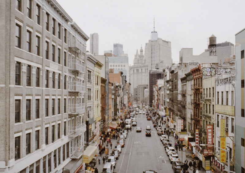 Elevated view of a busy New York street lined with buildings, cars and pedestrians
