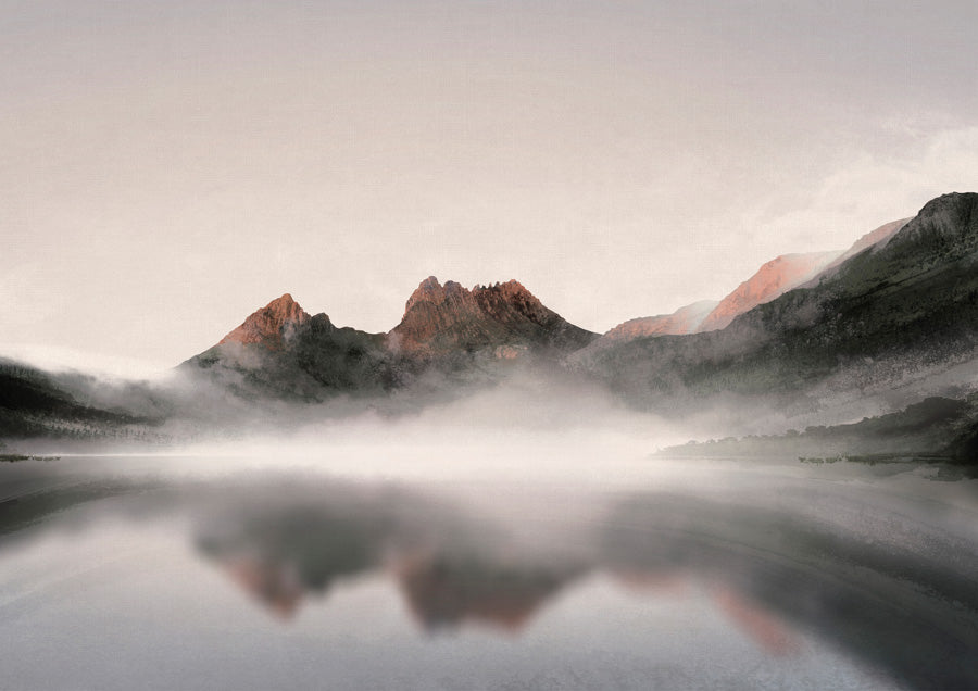 Misty mountain range with rust-toned peaks reflected in calm water beneath a pale sky
