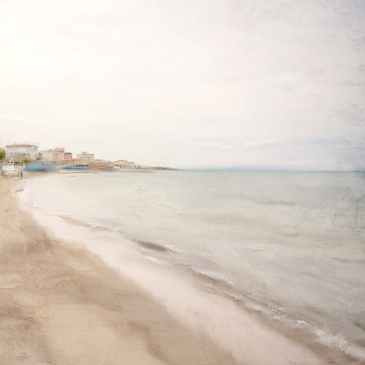 Painterly coastal scene of a sandy beach curving toward a distant seaside village