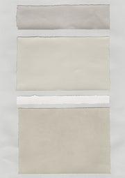 Torn paper swatches in gray, cream and white stacked in horizontal bands with deckled edges