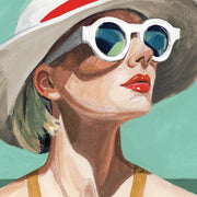 Portrait of a woman in a wide hat and round white sunglasses against teal background