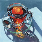 Watercolour still life of a glass teacup, saucer and spoon reflecting orange light