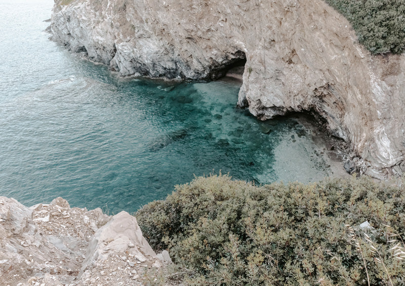 Aerial photo of a turquoise lagoon surrounded by pale limestone cliffs and coastal shrubs