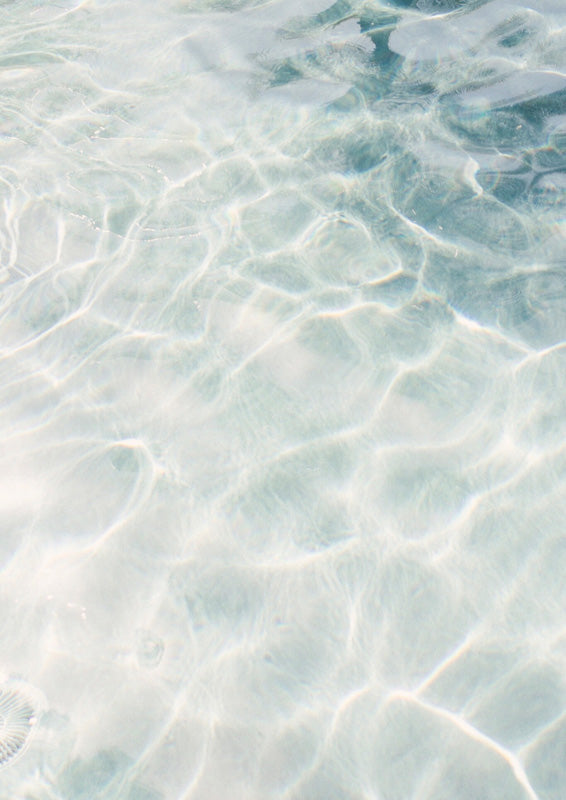 Close-up of clear turquoise water with rippling light patterns and pale reflections