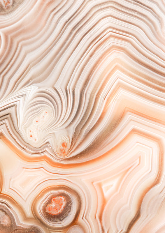 Close-up of banded agate stone in cream, tan and orange tones