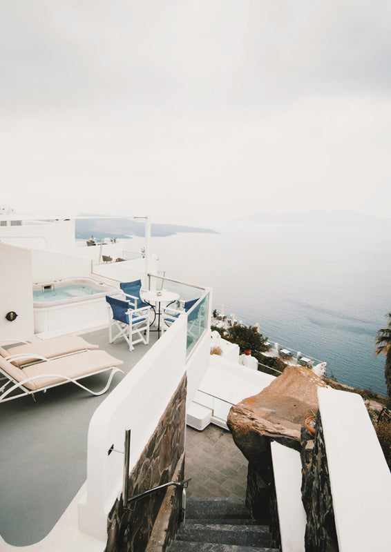 Whitewashed terrace with plunge pool and loungers overlooking the sea in Santorini