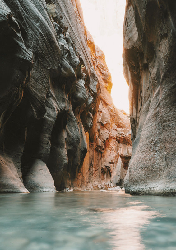 Narrow sandstone canyon with terracotta rock walls above a shallow teal river