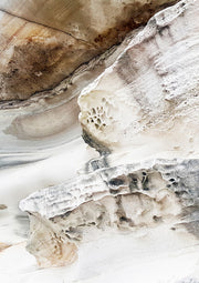 Close-up photograph of layered, eroded rock with ochre and pale stone textures