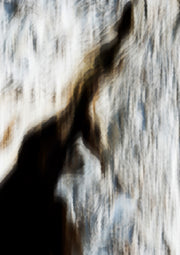 Blurred vertical bark-like texture in beige and brown with a dark diagonal shadow shape
