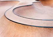 Close-up of curved concrete skate park bowl with black metal edging