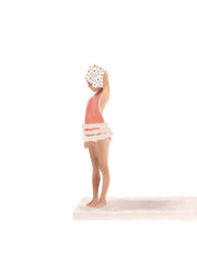 Illustration of a girl in a coral swimsuit and floral swim cap standing on a diving board