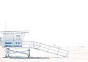 Lifeguard tower with ramp on a beach under a bright, hazy white sky