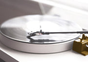 Close-up of a turntable with spinning vinyl record and gold tonearm cartridge