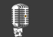 Vintage chrome microphone with ribbed grille against a dark grey background, small orange emblem at centre
