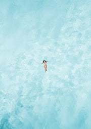 Aerial photo of a swimmer floating on light blue rippling water