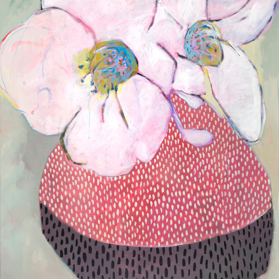 Pink orchid blossoms above a red and black dotted patterned vessel on sage background.